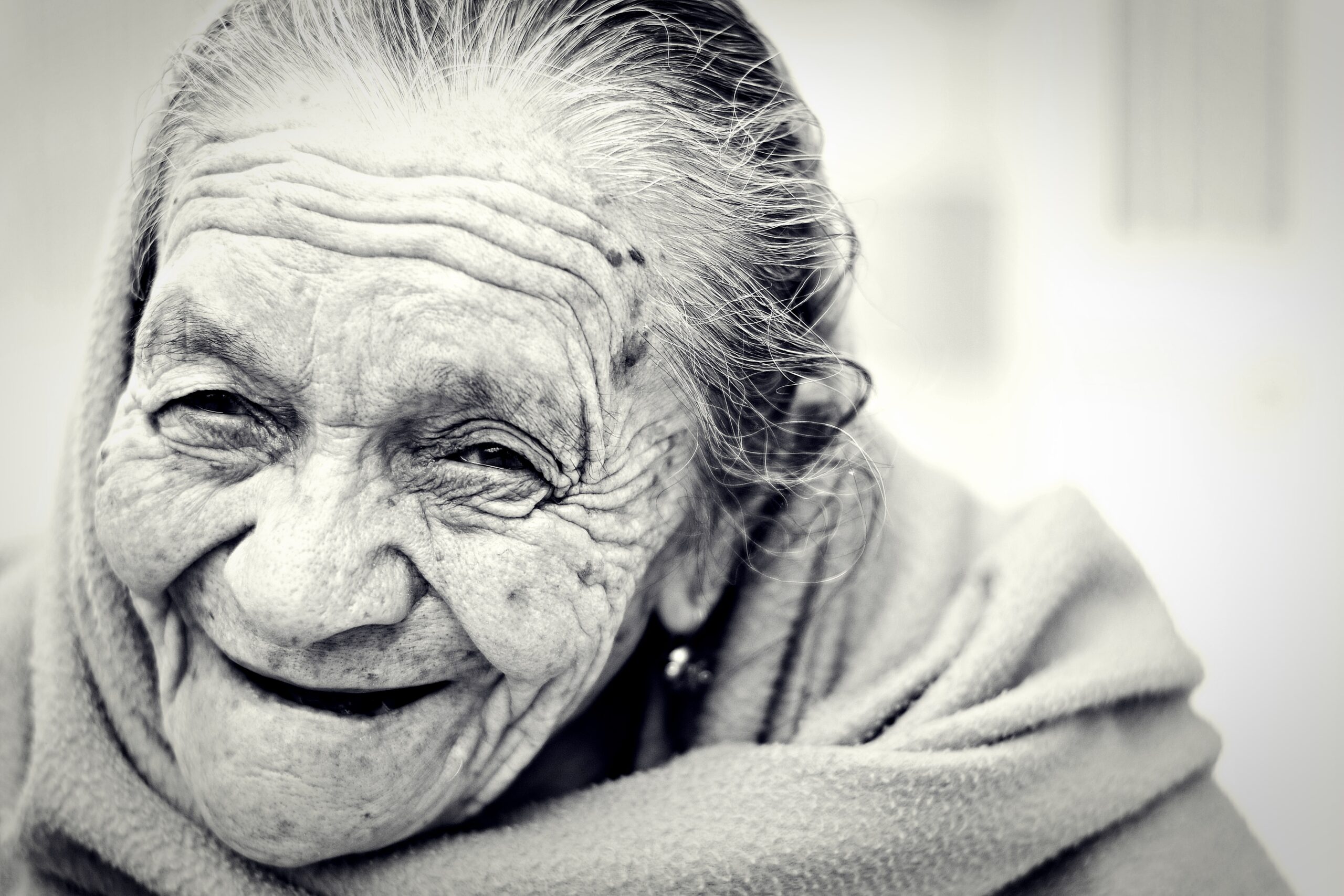 Zwart-wit foto van oude, blij kijkende vrouw